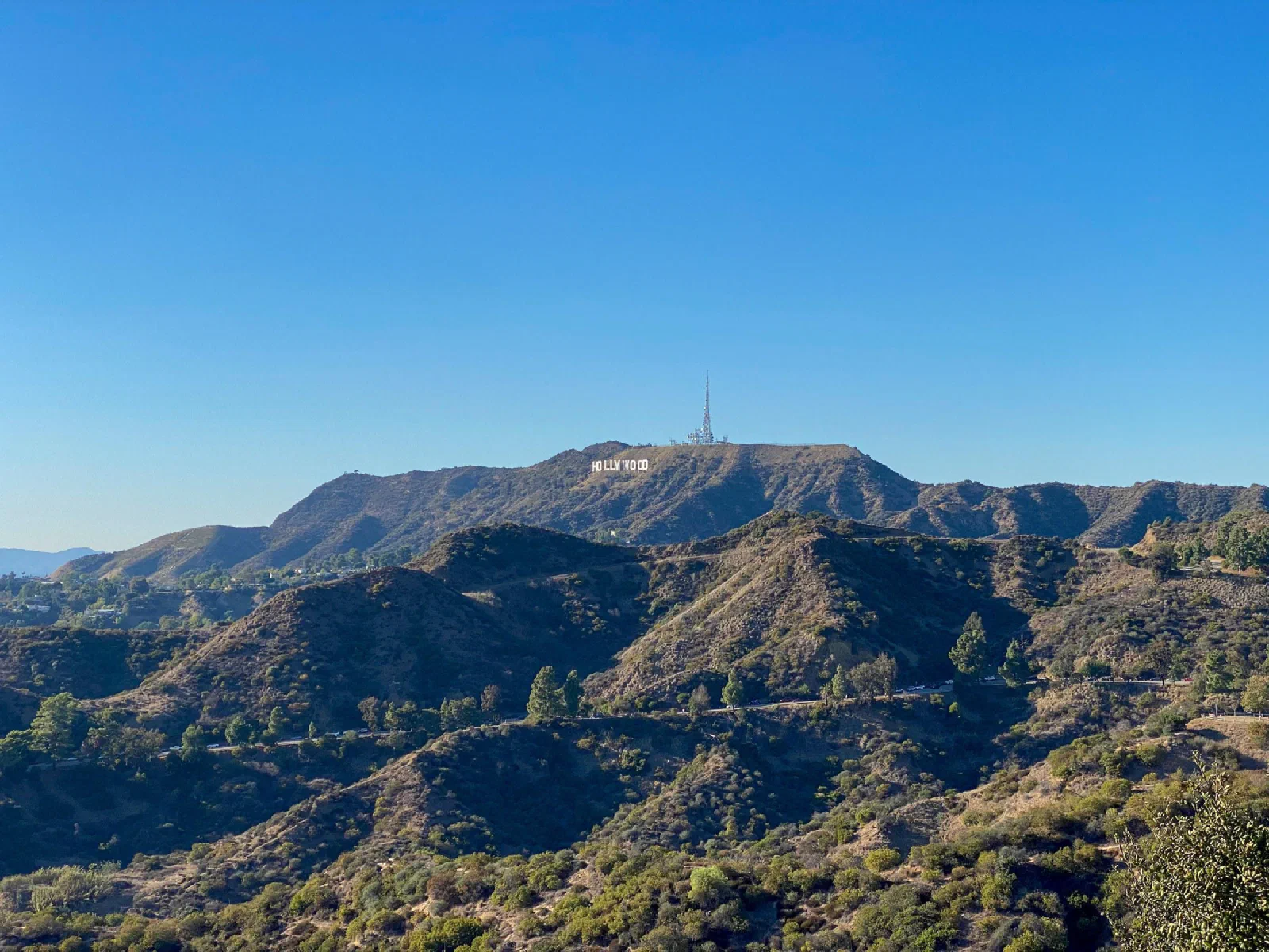 Dry hills and winding paths with the Hollywood sign visible in the distance.