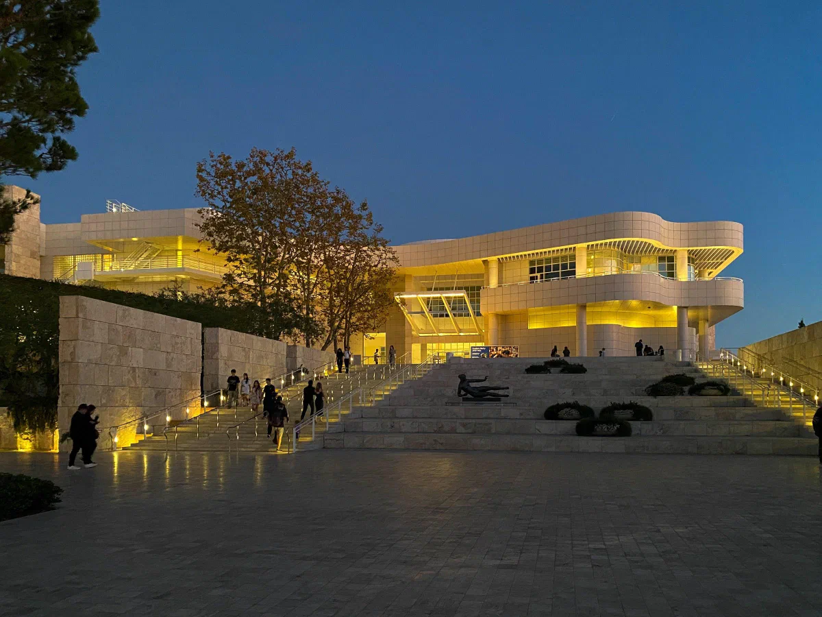 A brightly lit modern building above wide steps at dusk.