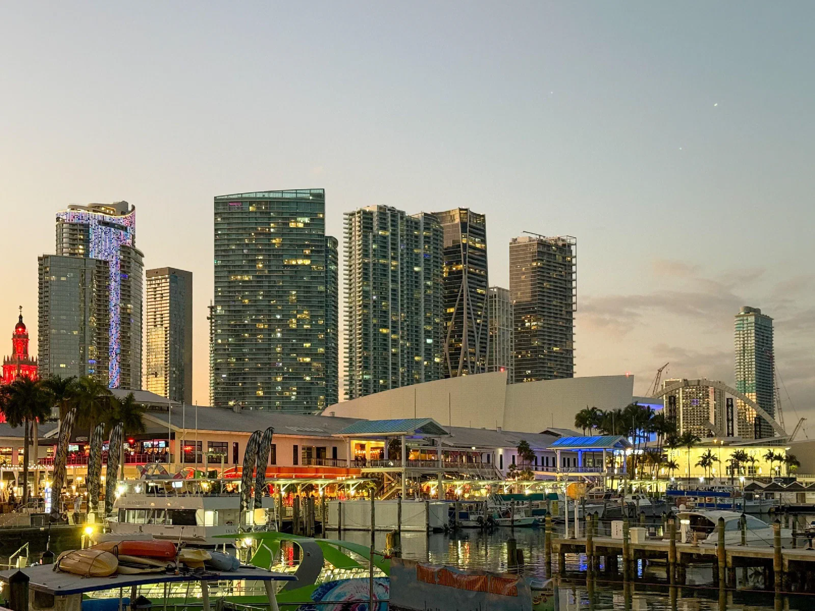 Waterfront buildings and a marina beneath an evening sky.
