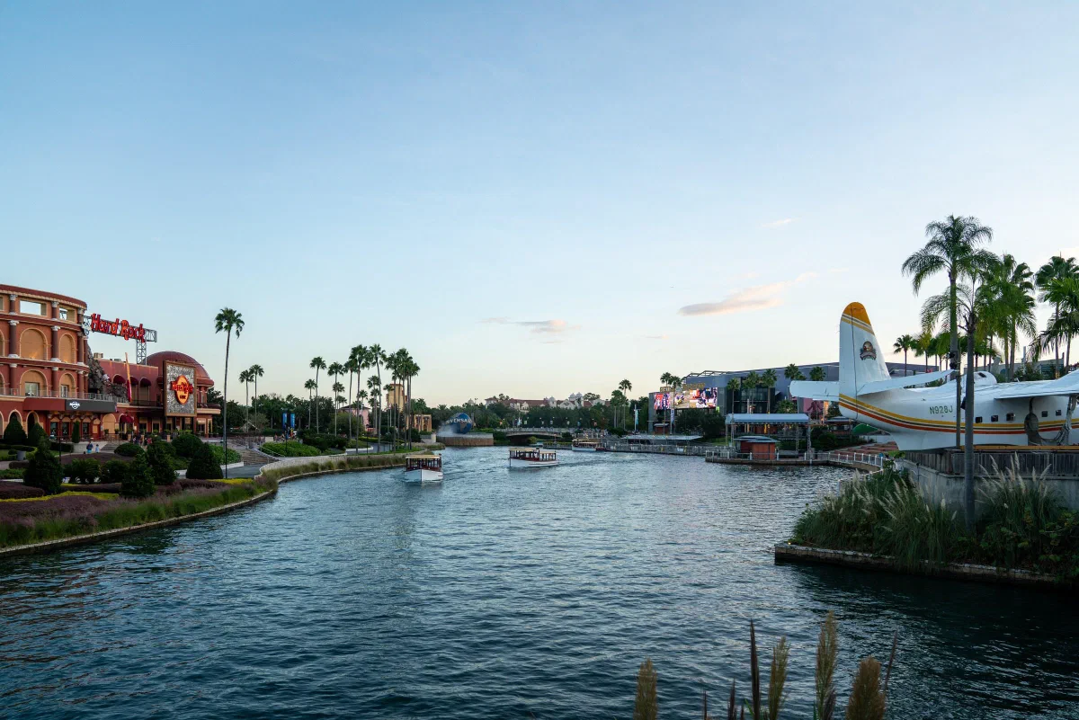 A waterway bordered by colorful low buildings and palm trees.