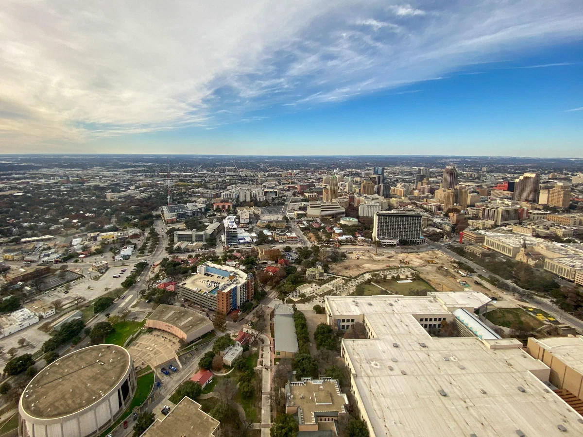 City buildings, roads, and curved landscaped paths seen from high above.