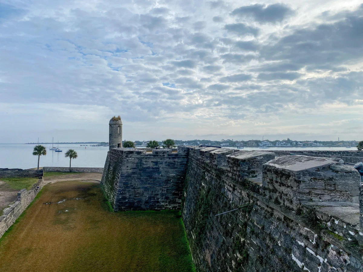 Weathered stone fort walls and a small corner tower overlooking the water.