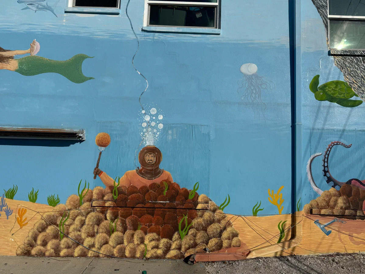 A painted underwater mural showing a diver, fish, and sea life on a blue wall.